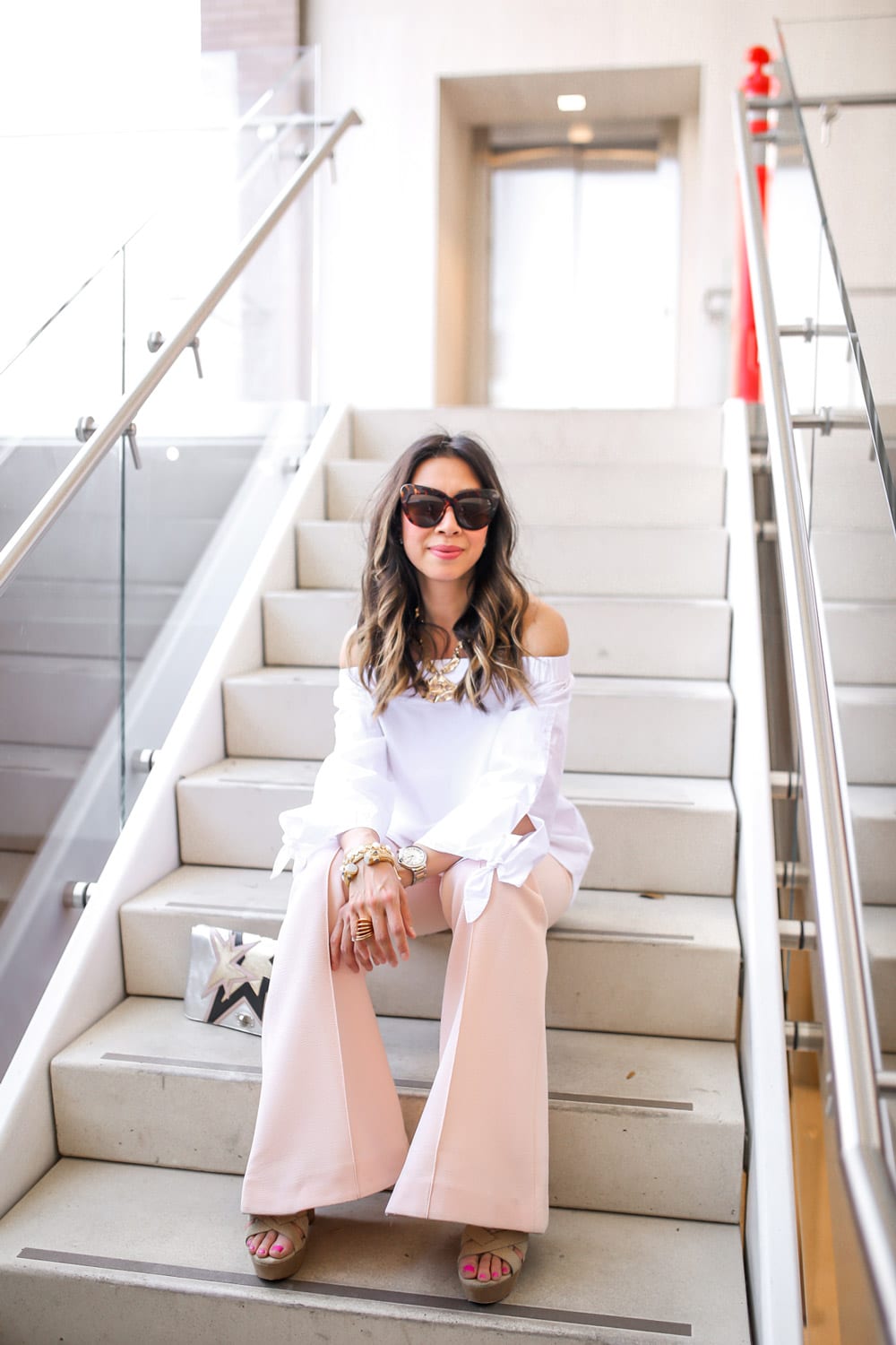 style of sam in white off the shoulder top and ellery peach pink flare trousers