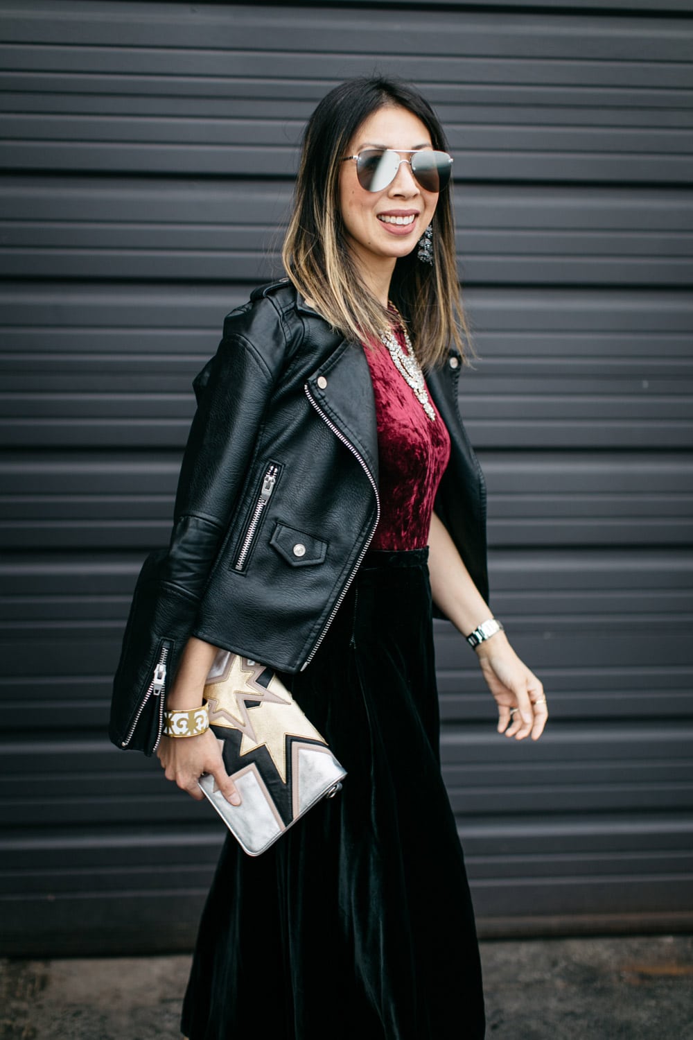 easy holiday outfit, burgundy velvet bodysuit with black midi skirt and moto jacket, statement necklace