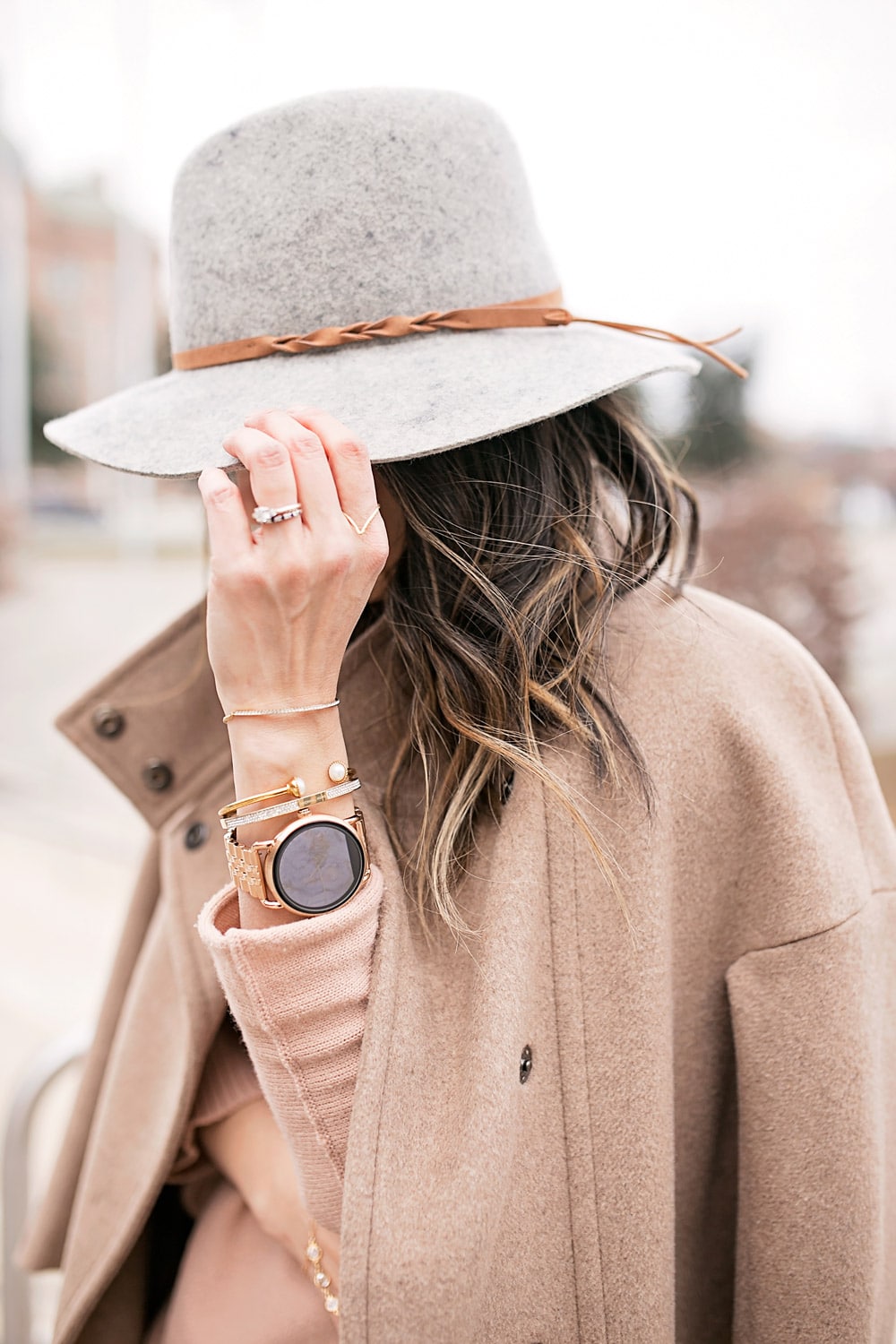 fossil q wander rose gold smartwatch, tan off the shoulder sweater with max mara coat,grey fedora