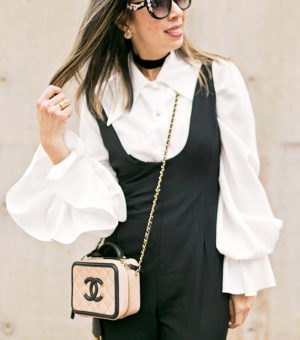 vintage black jumpsuit with bishop sleeve top and chanel black and tan vanity bag