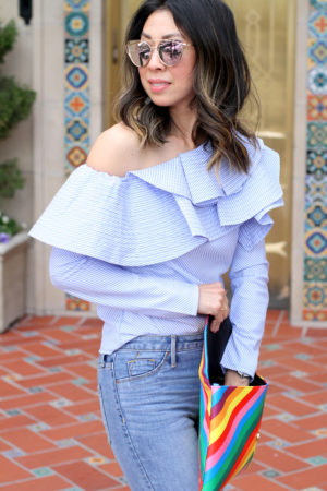 stylekeepers ruffle one shoulder top with ripped knee skinny jeans and rainbow clutch, pink pumps