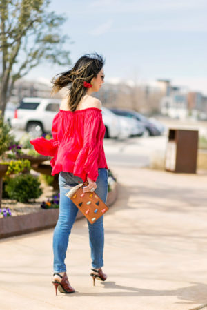 fossil tassel pouch, red off the shoulder top, amo twist jeans, balenciaga red glove sandals, galentines day outfit