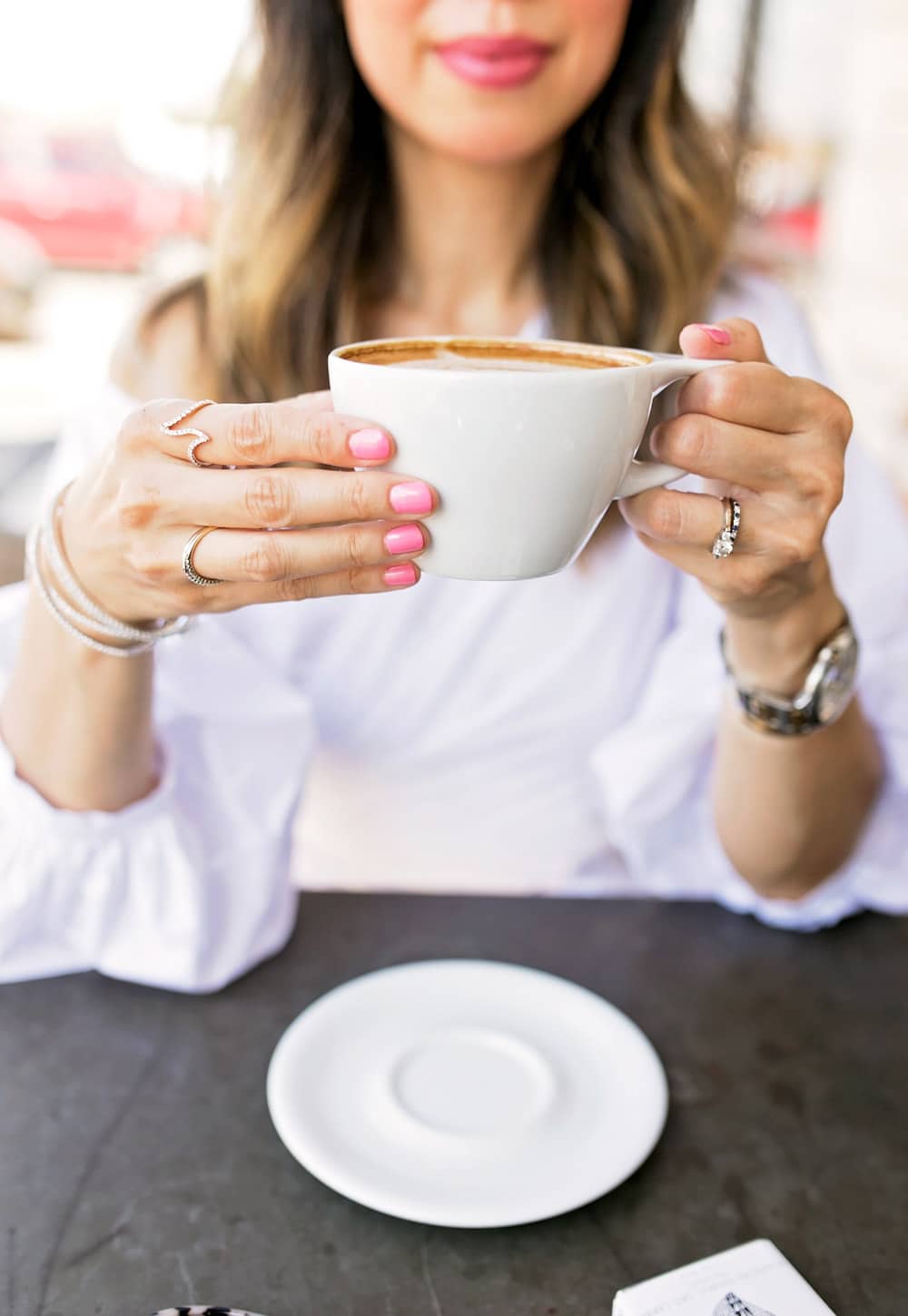 chic lady drinking cappuccino with pink nails diamond jewelry