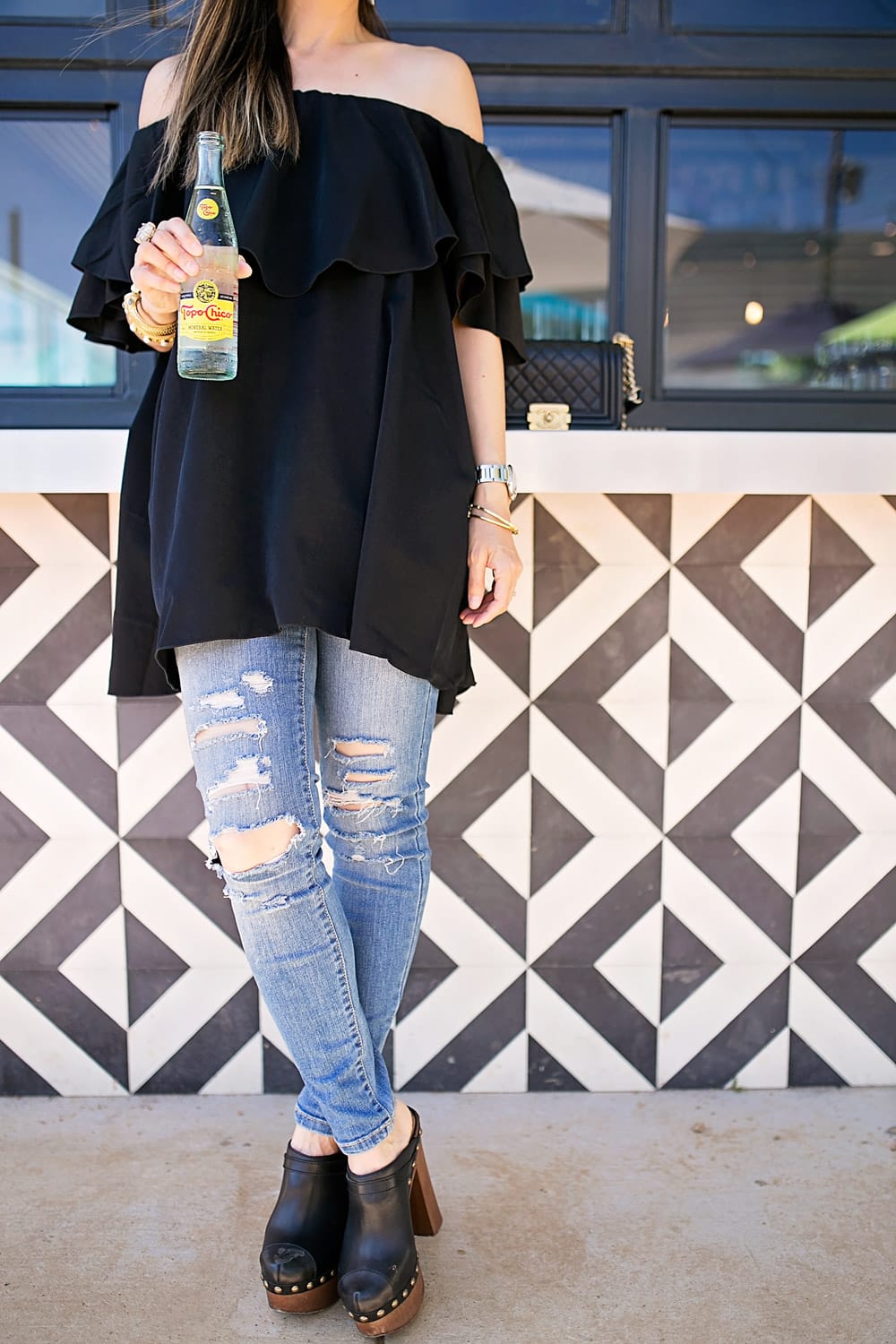 topo chico mineral water off the shoulder black ruffle top ripped jeans chanel platform clogs
