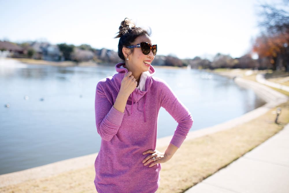 blogger exercising by lake with purple hoodie sunglasses