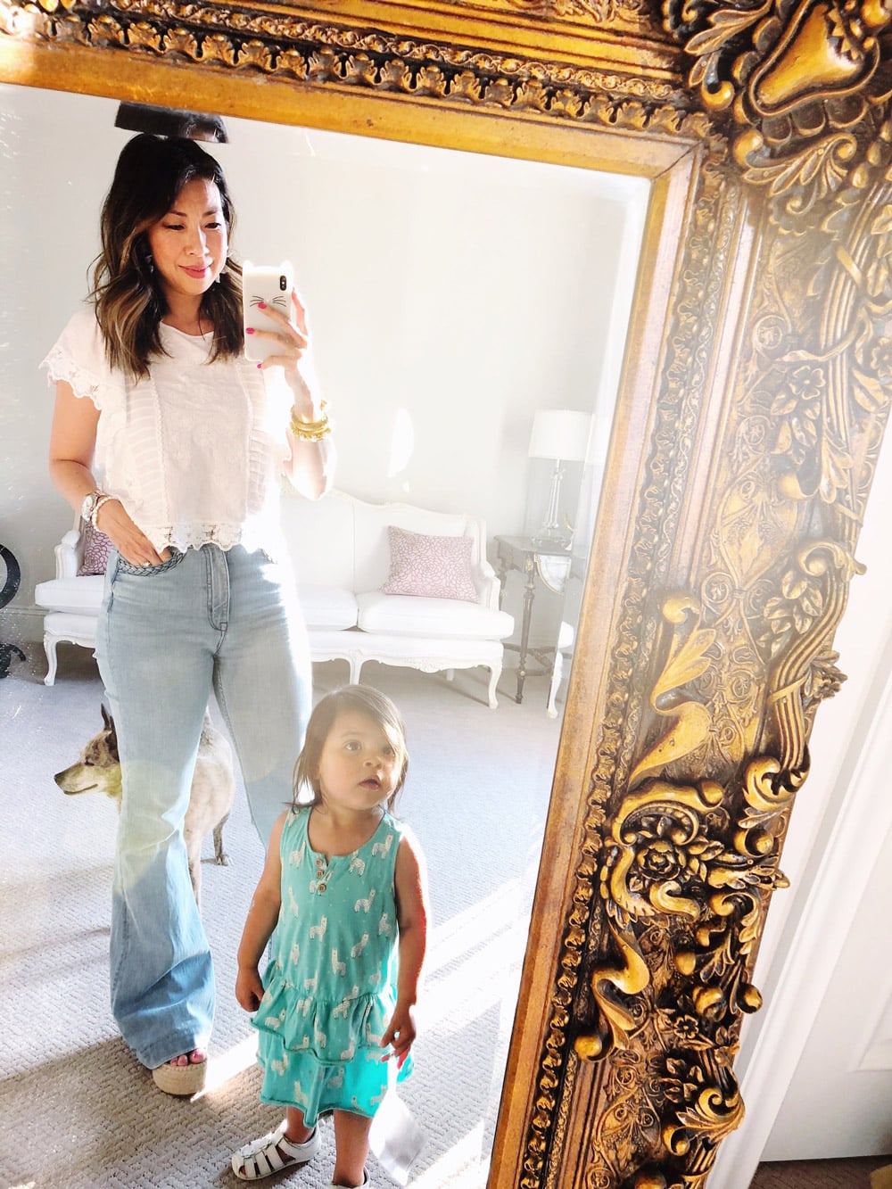 style of sam mirror selfie in white ruffle sleeve top and light wash flare jeans with daughter