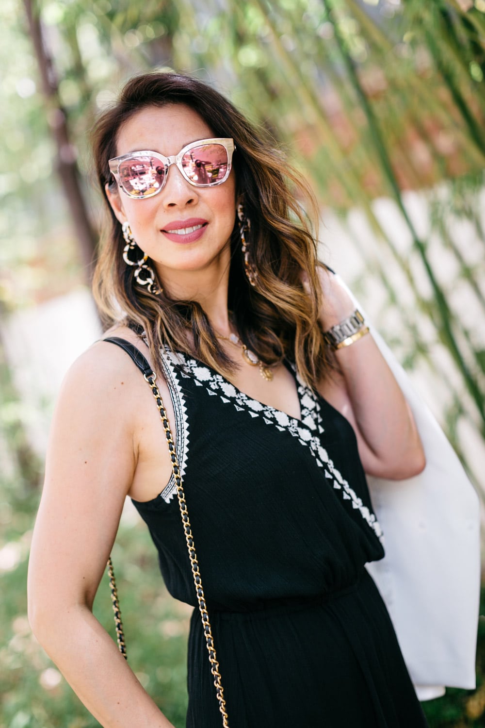 style of sam in black jumpsuit with lele sadoughi wind chime earrings and dior reflective sunglasses