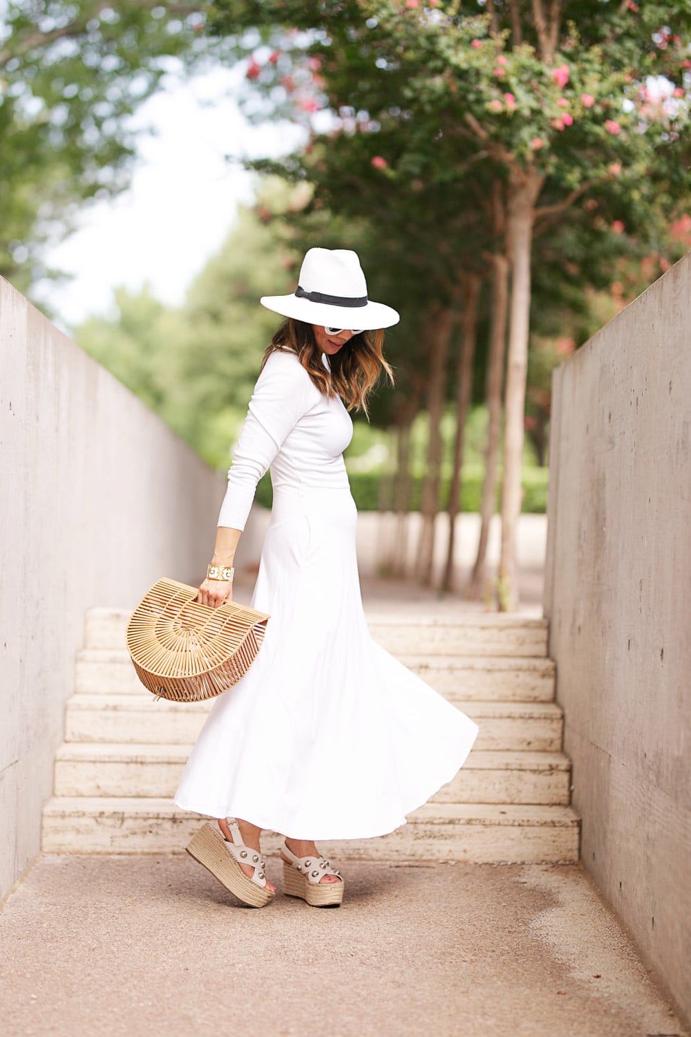 style of sam in white midi dress fedora hat bamboo arc bag twirling