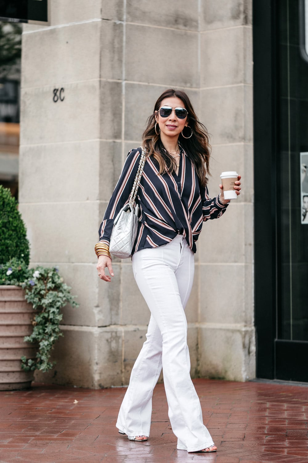 style of sam in striped draped top white flare jeans silver chanel maxi bag