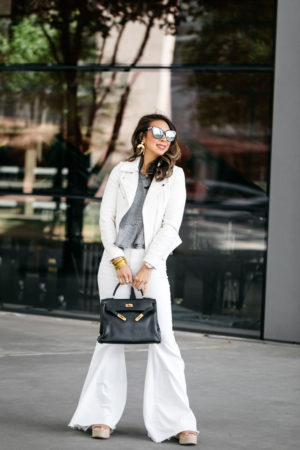 style of sam in white moto jacket, flare jeans, and hermes kelly bag, white summer suit