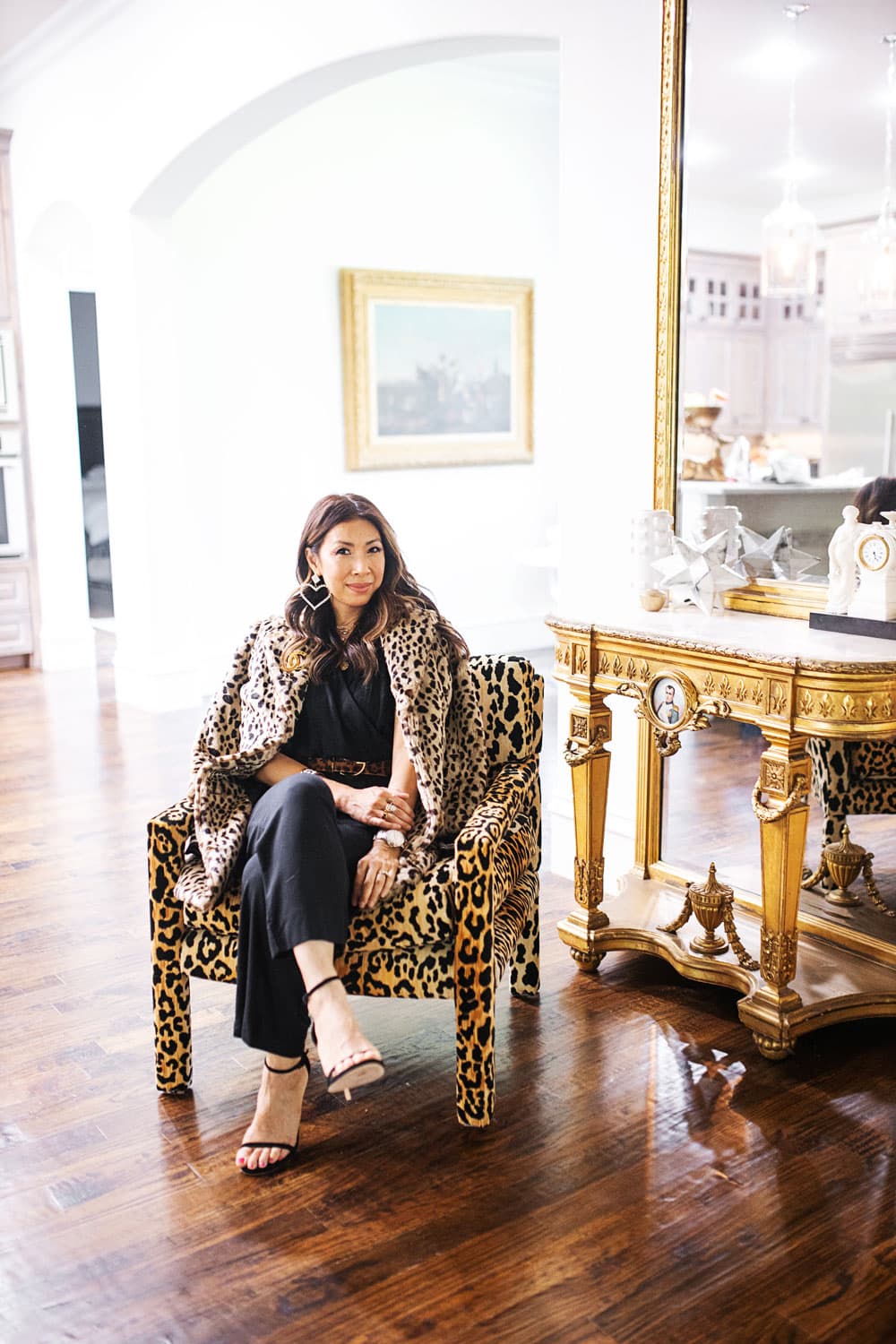 style of sam in cabi josephine leopard coat, downtown jumpsuit, beast belt at home with leopard parson chairs