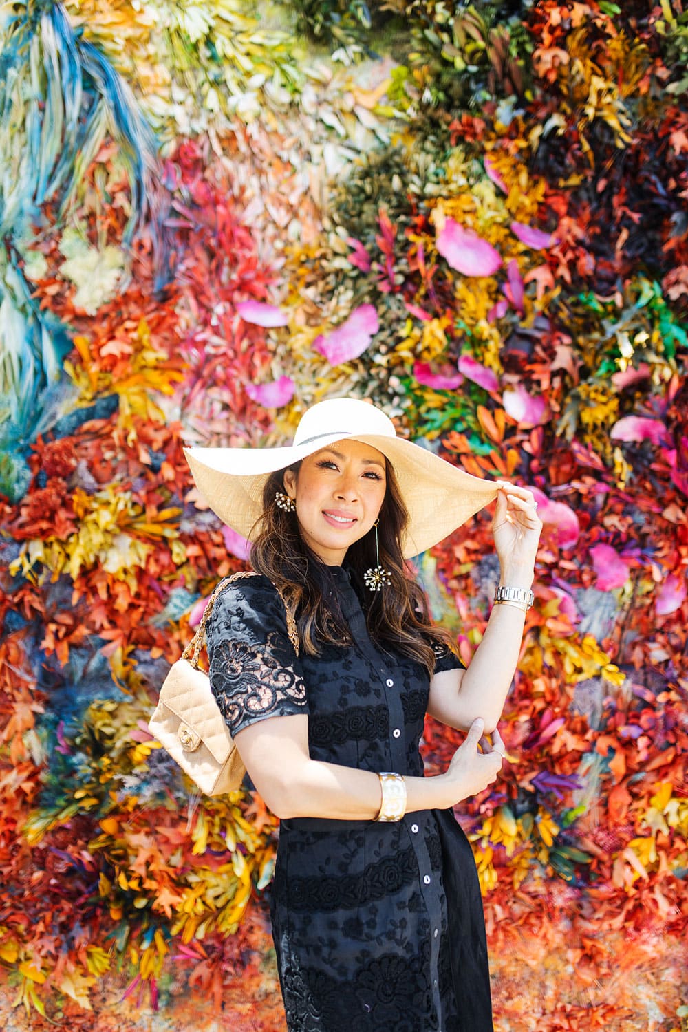 style of sam in black lace dress and cuyana large brim hat at monet wall in fort worth