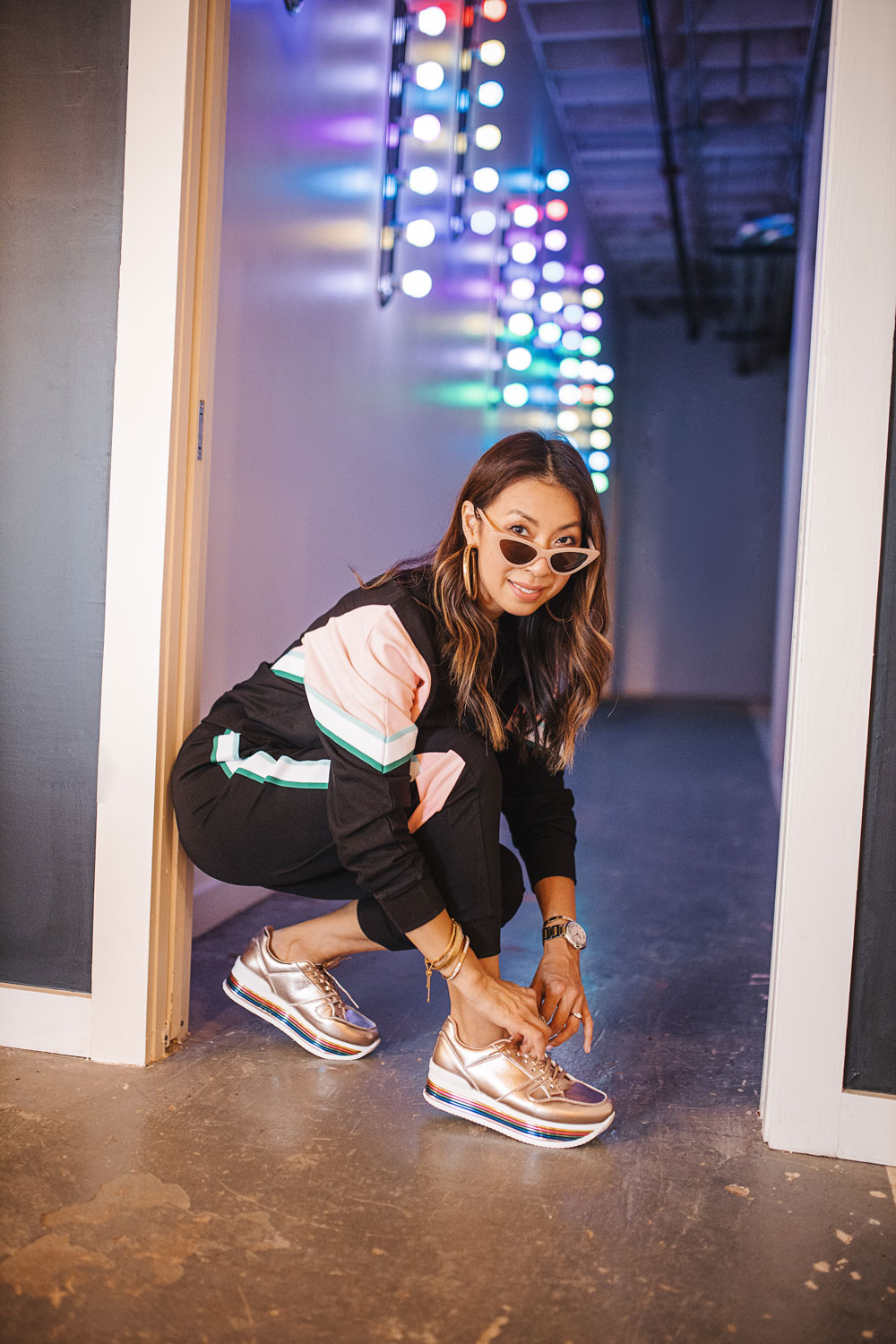 style of sam in 90s track suit, rose gold rainbow sneakers
