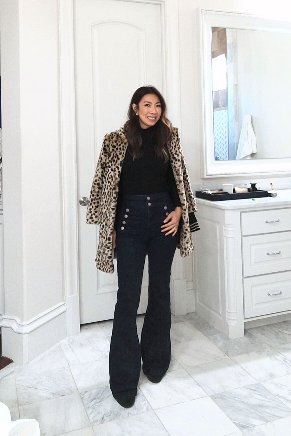 style of sam in winter outfit idea - black turtleneck, flare jeans, leopard coat