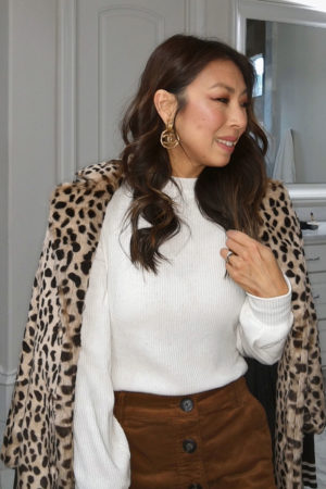 style of sam in winter outfit idea - vintage chanel earrings, cream turtleneck, button front corduroy skirt, leopard coat
