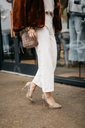 style of sam in faux wrap top winter white outfit, brown faux fur jacket, gucci pearl camera bag
