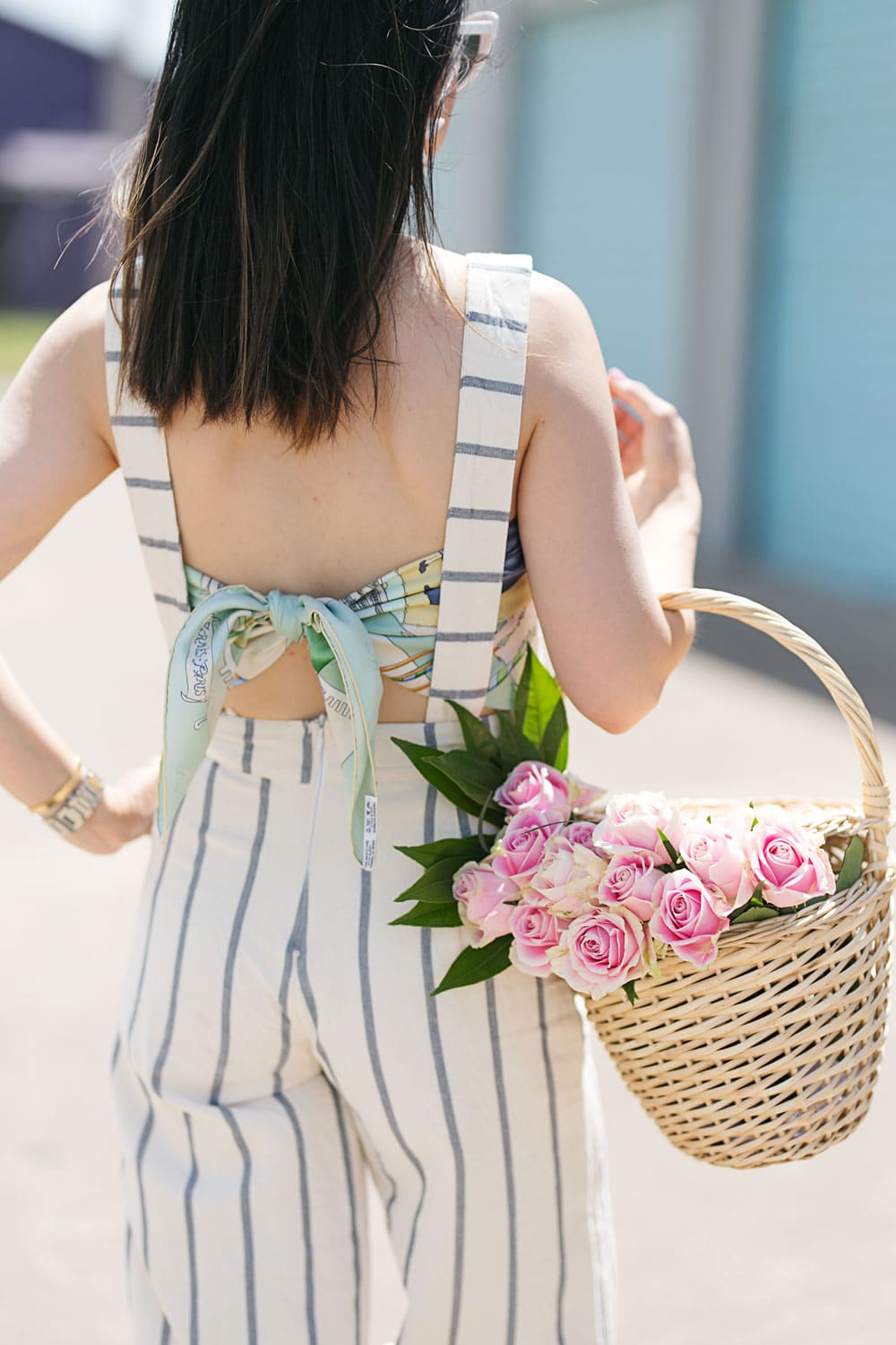 style of sam in tribe alive striped overalls with vintage hermes scarf as top and basket of pink roses