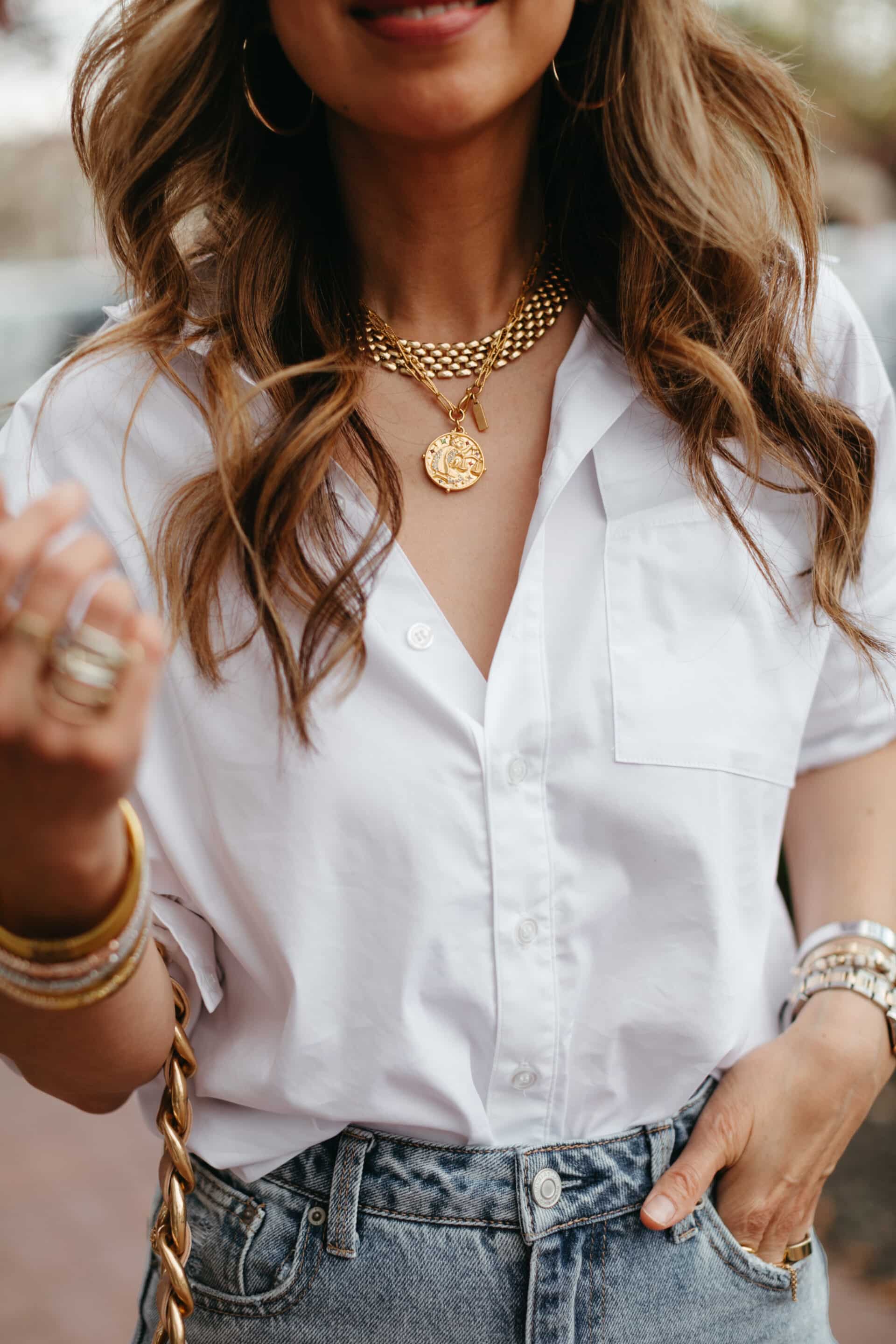 Layered gold jewelry paired with classic white shirt 